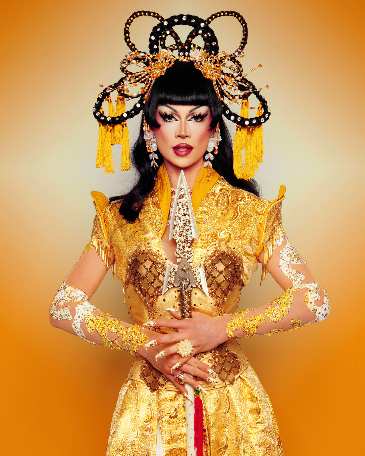Ivory Glaze in an ornate gold costume with a black and gold headdress